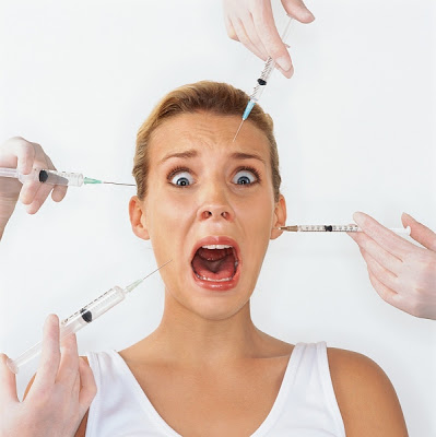 the girl with a scared face as four syringes with botox are close to her face 