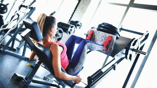 Girl is doing leg press in the gym