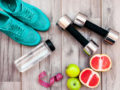 Running shoes, dumbbells, water bottle and fruit are on the wooden background