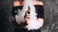 Girl holding vape and releasing the smoke