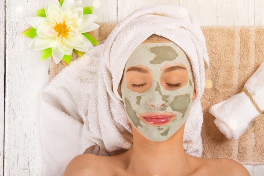 A girl lying with a mask on her face and a towel on the head