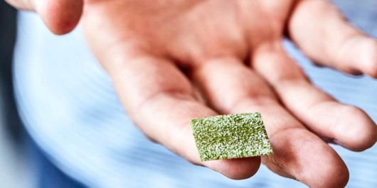 A close up Marijuana Sublingual Strip on guy's finger