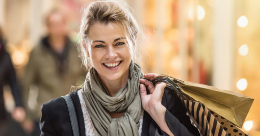 A good looking girl is happily doing shopping