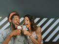 A man and a woman are having fun and eating ice cream together