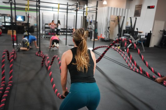 Girl in fitness outfit is exercising in the gym