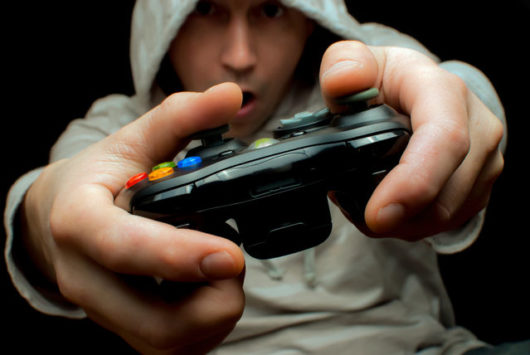 A guy in a hoody and with a gamepad on black 