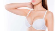 A girl in white bra on white showing her breast after breast augmentation