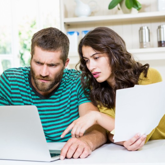 A couple is looking into the laptop and checking the prices of the clinics 