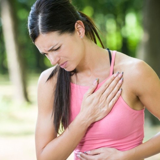 Girl with the pain in her chest. Girl put her hand on her chest where she has pain 