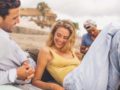 A man and a woman on the beach are talking and flirting to each other