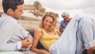 A man and a woman on the beach are talking and flirting to each other