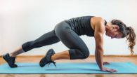 Fit and strong girl exercising on the green mat