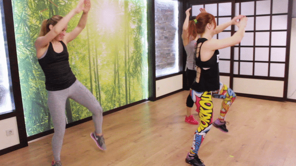 Three Girls are warming up before the hiit workout doing Knee Thrusts With Double Tap