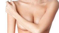 A close up body of the girl who covers her breasts with her arm