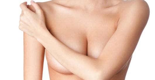 A close up body of the girl who covers her breasts with her arm