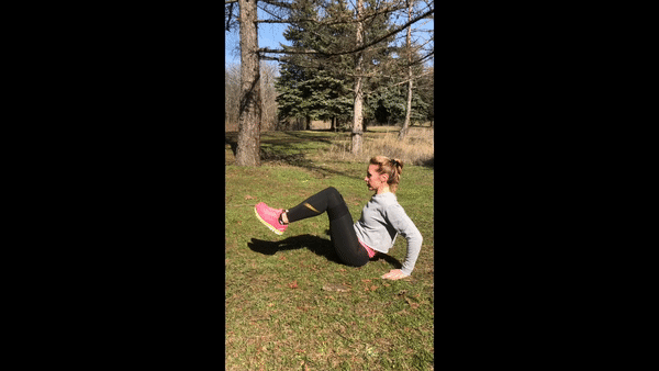 Girl is exercising outside doing V-Sit ups Into Wide Knees exercise. Girl doing leg and butt workout