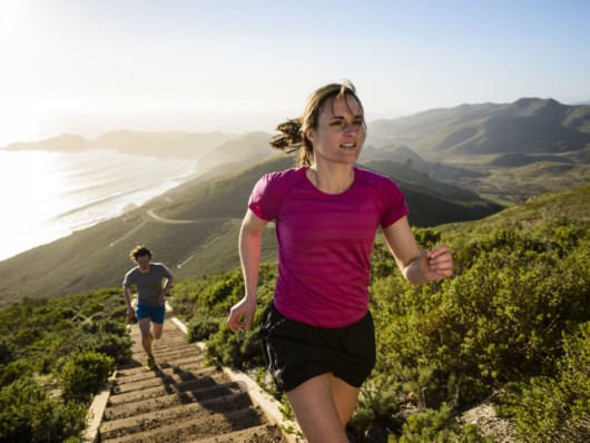 Girl and guy are running up the stairs outdoor