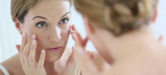Girl is checking her face after the plastic surgery