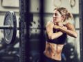 Fit looking girl is standing at the bar rack. She is trying to beat addiction through fitness