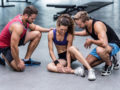 Girl in the gym sitting on the floor with a sprained ankle