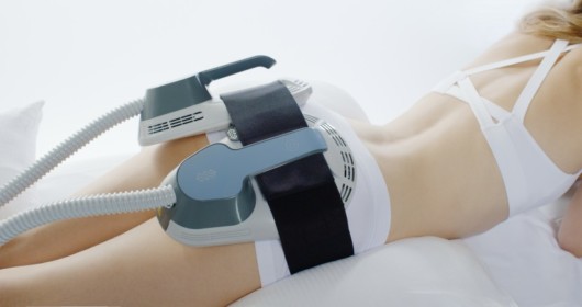 A girl is doing EmSculpt non-invasive procedure that uses focused electromagnetic energy to stimulate muscle contractions