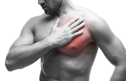 Man keeps his hand on pectoral muscles where he has the injury