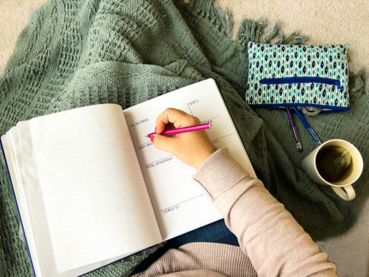 A girl is writing down her thought in the diary to calm herself down 