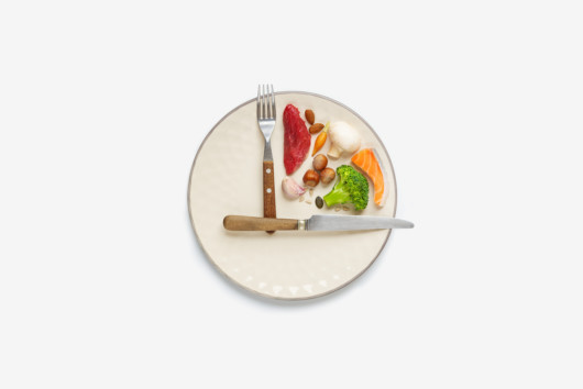 A white plate with fork and knife that show 3pm and food in between on the white background