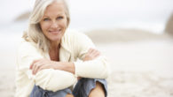 Senior Woman On Holiday Sitting On Winter Beach