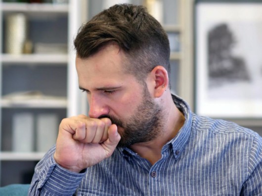 Man holding his hand at his mouth when he coughs 