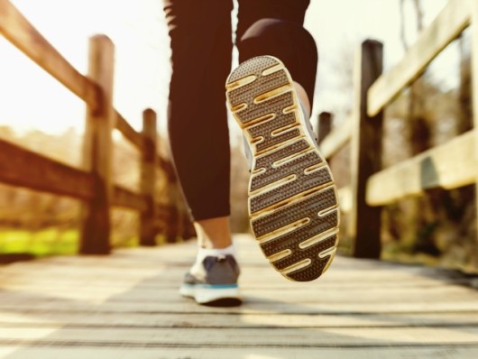 Girl is running on the wooden bridge in summer