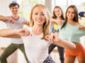 a group of young people are happily dancing and exercising