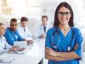 A girl in the doctor's outfit and stethoscope looks into the camera and smile