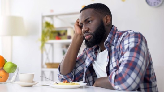 a man sitting at the table with the plate on and not eating. The man lost his appetite 