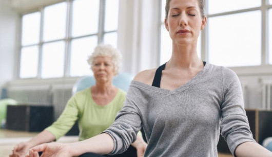 2 women are doing yoga as alternative cancer treatment