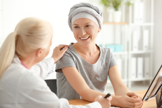 The doctor is talking with the girl with cancer. the girl with cancer is smiling and in a mood