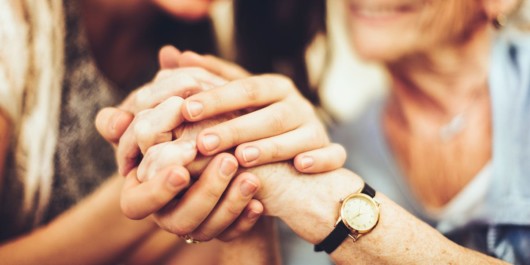 Girl is holding the grandma's hands inn her hands