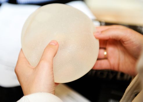 Girl is checking the implant before the breast augmentation procedure