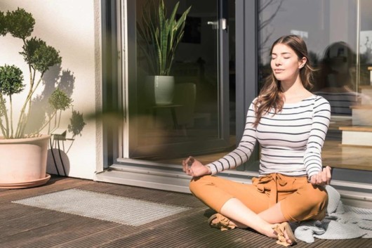 Girl is sitting outside in the sun and meditate