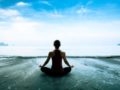 Girl is sitting in lotus pose on the beach