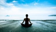 Girl is sitting in lotus pose on the beach