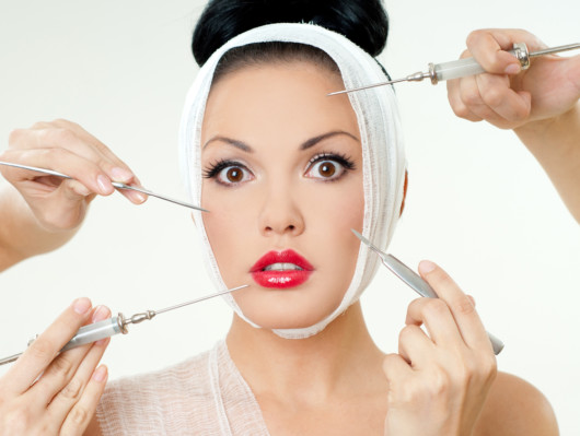 A beautiful girl with red lips and the bandage around her head on the white background