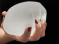 Girl is holding breast implant in her hand
