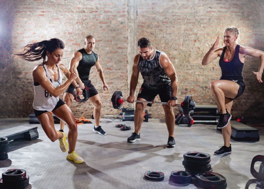 Two men and two women doing hiit workout in the gym 