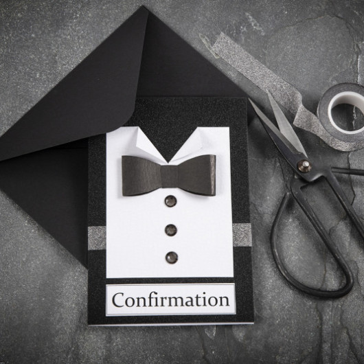 Confirmation invitation layout with a black envelope and scissors and a grey tape on the grey background 