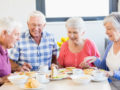 4 seniors sitting at the table having lunch together