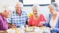 4 seniors sitting at the table having lunch together