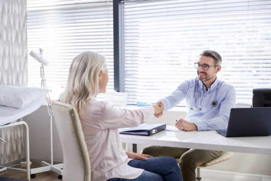 A mature female is shaking hands with doctor at the consultation about popular plastic surgery procedures 