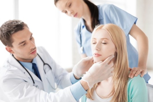 A doctor and a nurse examining the woman's face