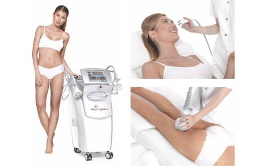 A beautiful girl on the white background is standing next to Venus Legacy device. She is treating her face and legs with Venus Legacy Treatment.